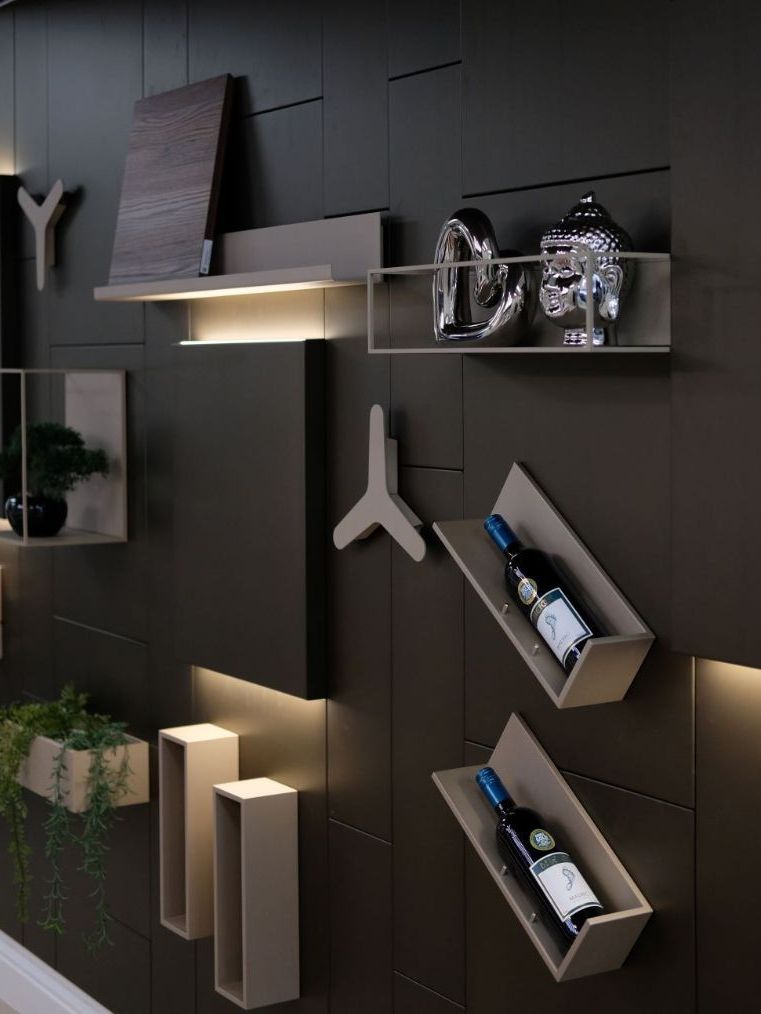 Modern wall display with shelves, varying shapes, and ambient lighting, showcasing decor and wine bottles.