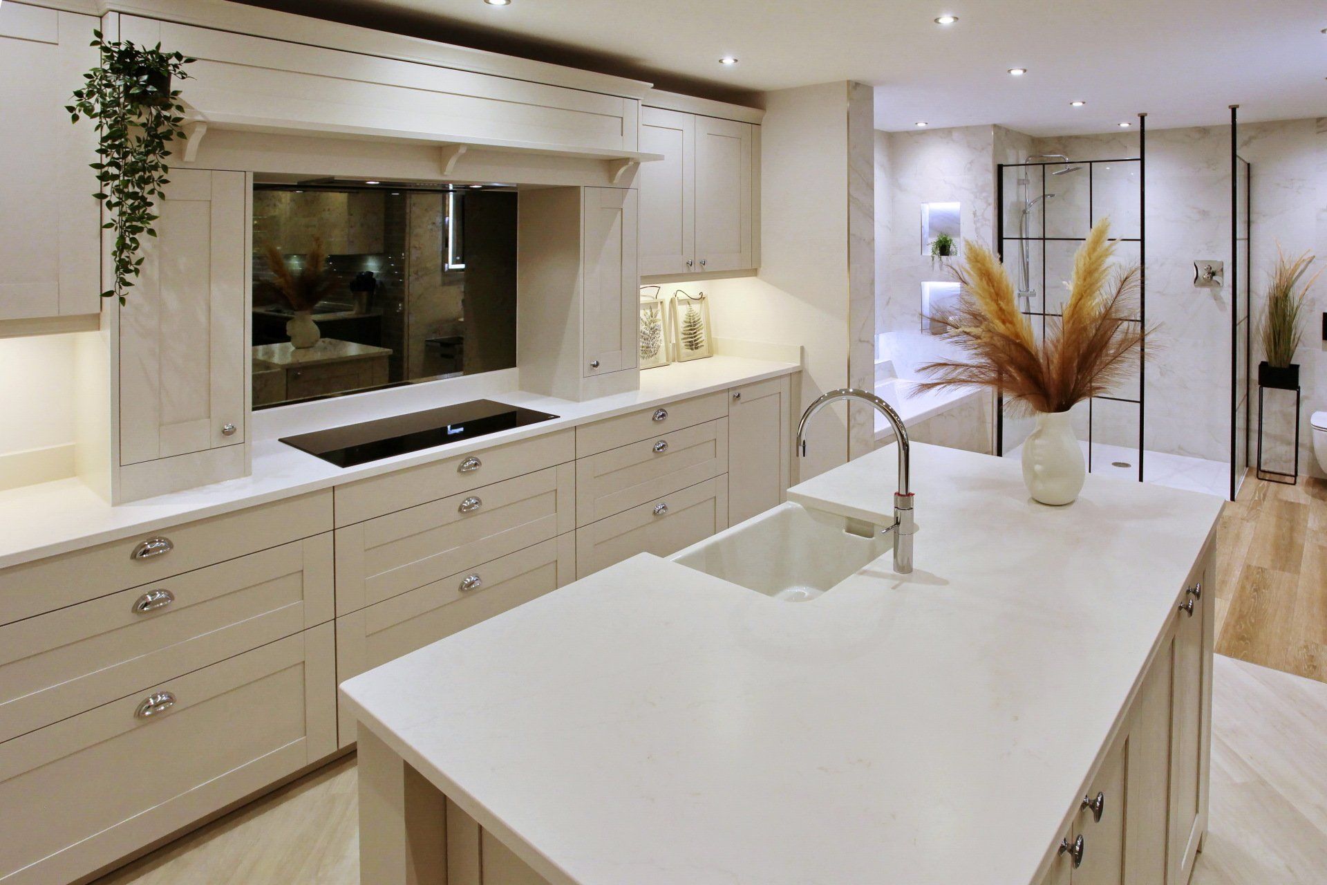 Modern kitchen with light cabinets, an island, and a sink.