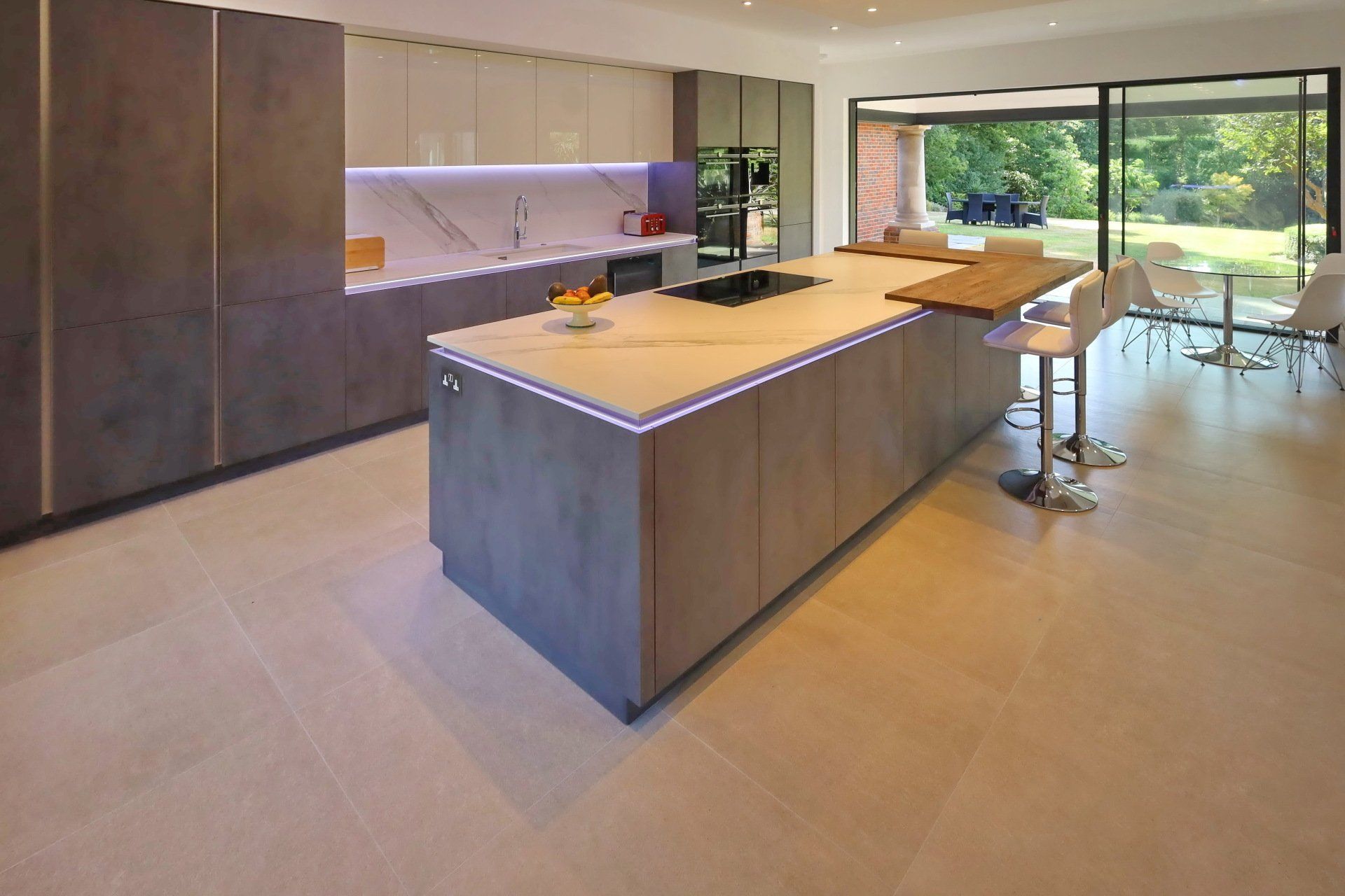 Harvey contemporary kitchen with grey, handleless units and teal furnishings. Designed by exact Kitchens in Wokingham.