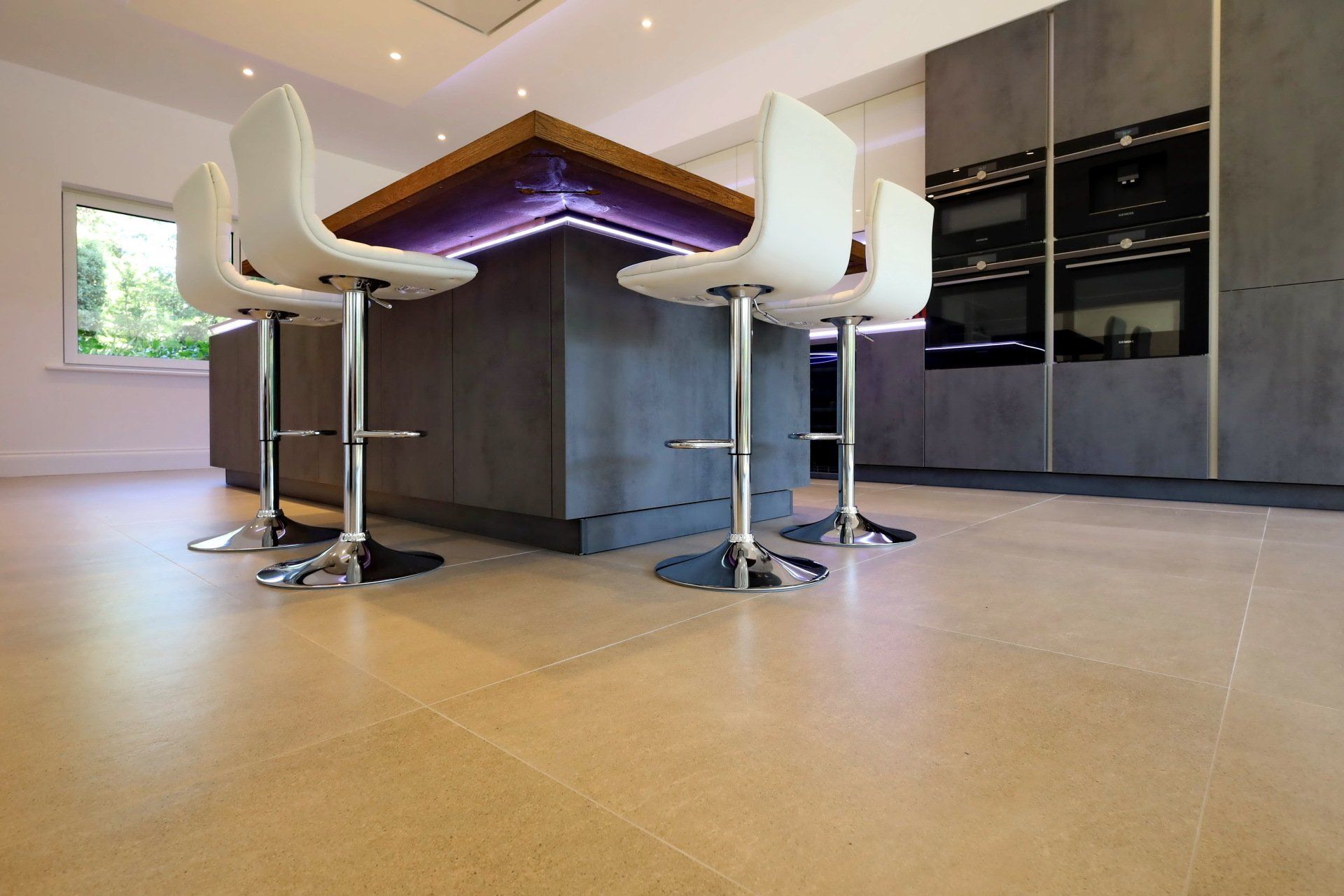 Harvey contemporary kitchen with grey, handleless units and teal furnishings. Designed by exact Kitchens in Wokingham.