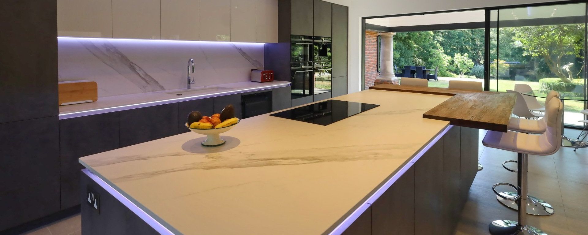 Harvey contemporary kitchen with grey, handleless units and teal furnishings. Designed by exact Kitchens in Wokingham.