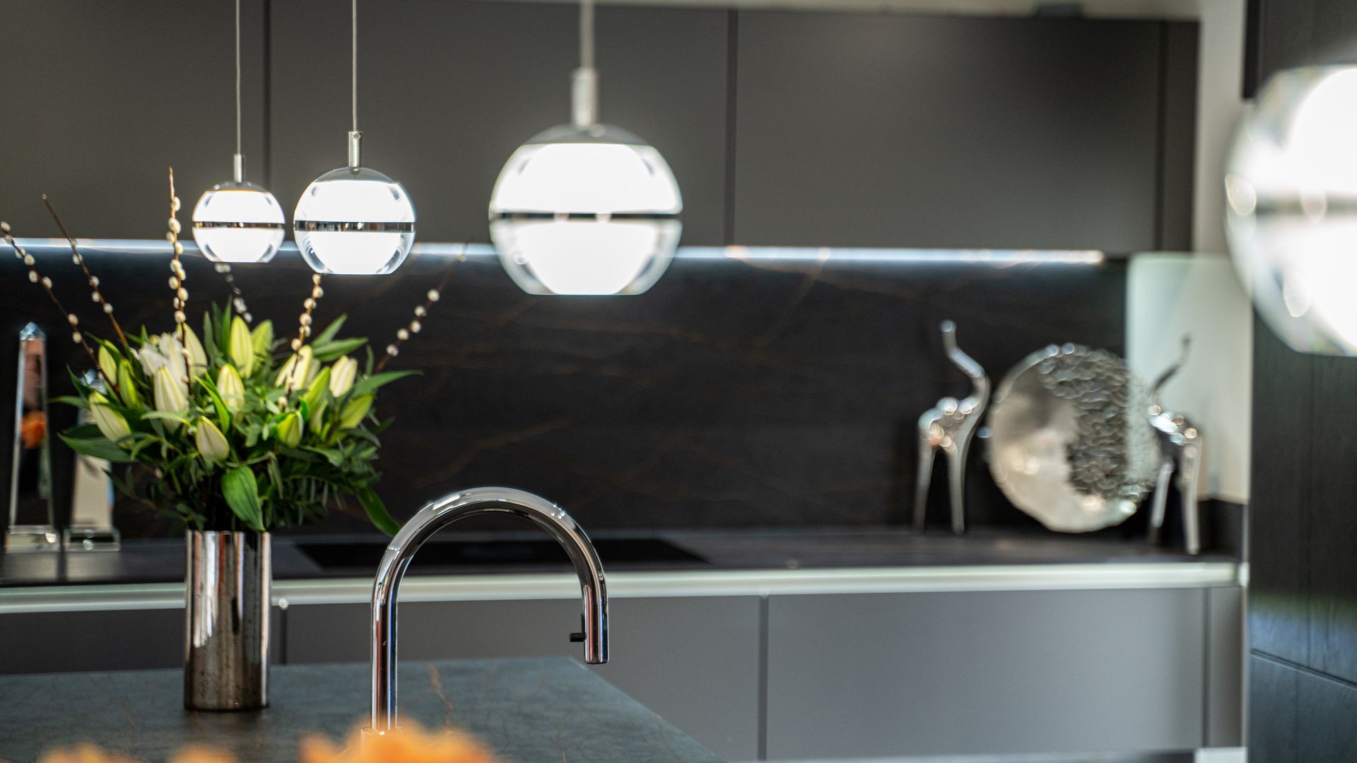 Harvey contemporary kitchen with grey, handleless units and teal furnishings. Designed by exact Kitchens in Wokingham.