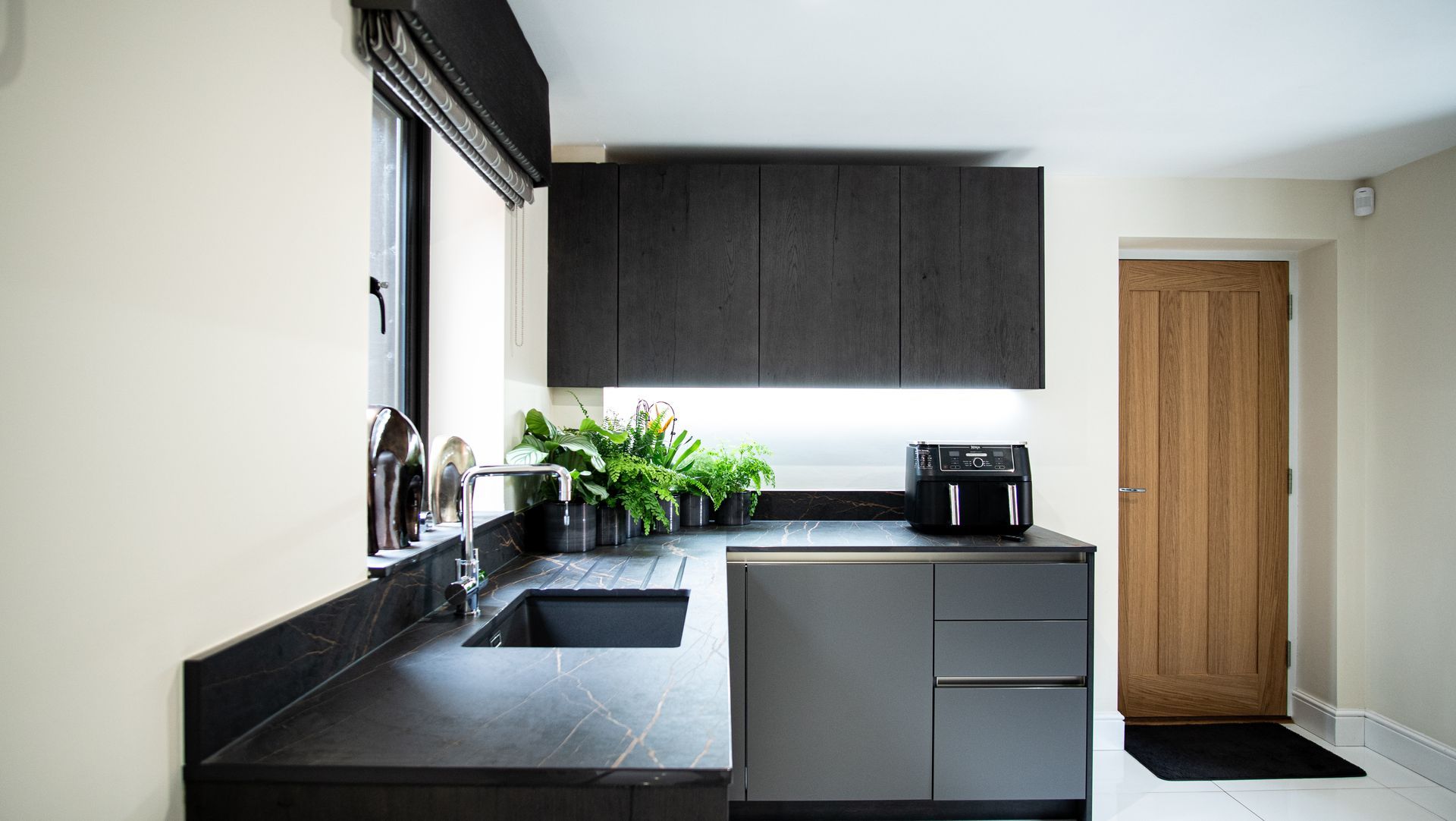 Harvey contemporary kitchen with grey, handleless units and teal furnishings. Designed by exact Kitchens in Wokingham.