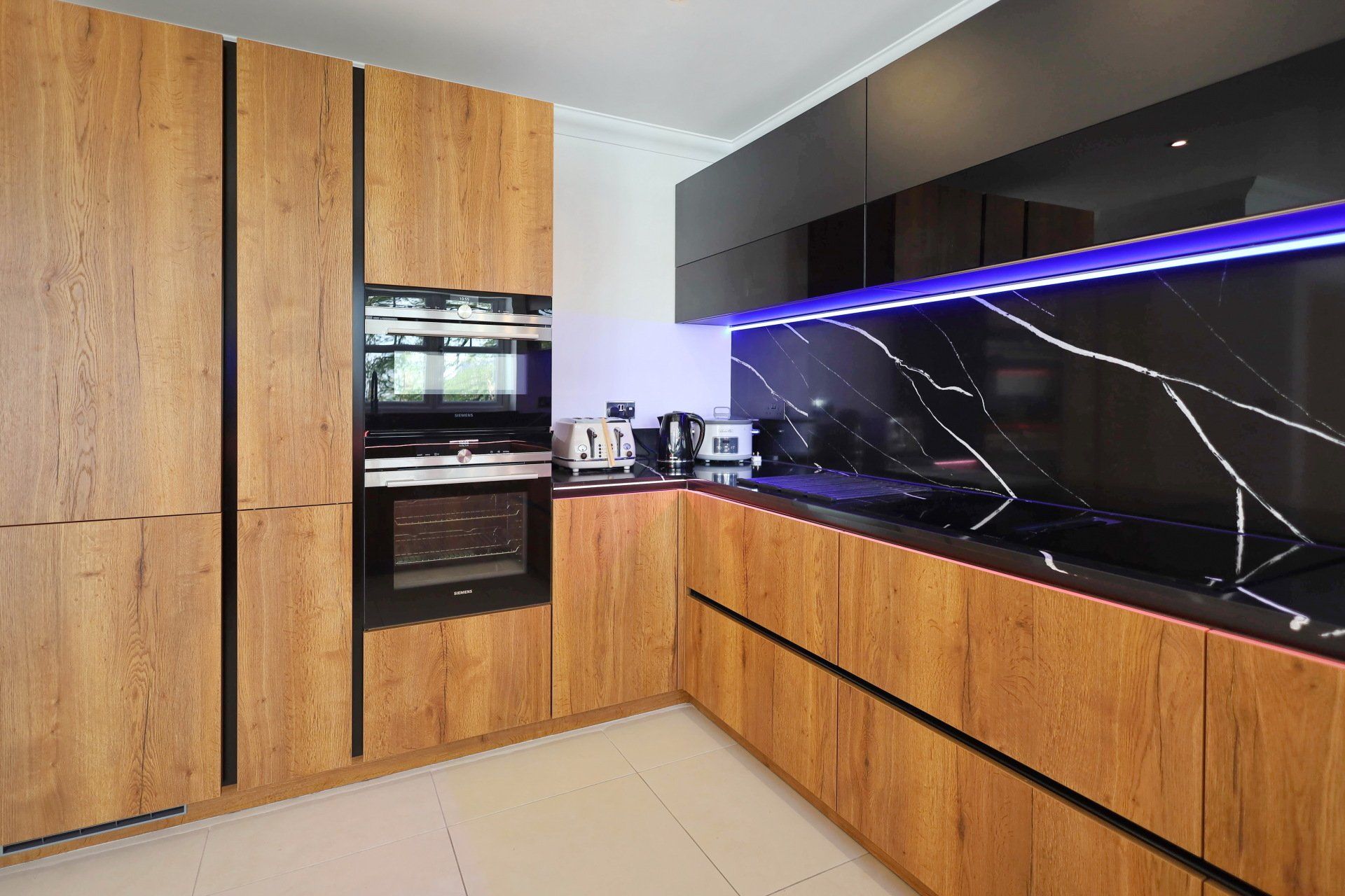 Harvey contemporary kitchen with grey, handleless units and teal furnishings. Designed by exact Kitchens in Wokingham.