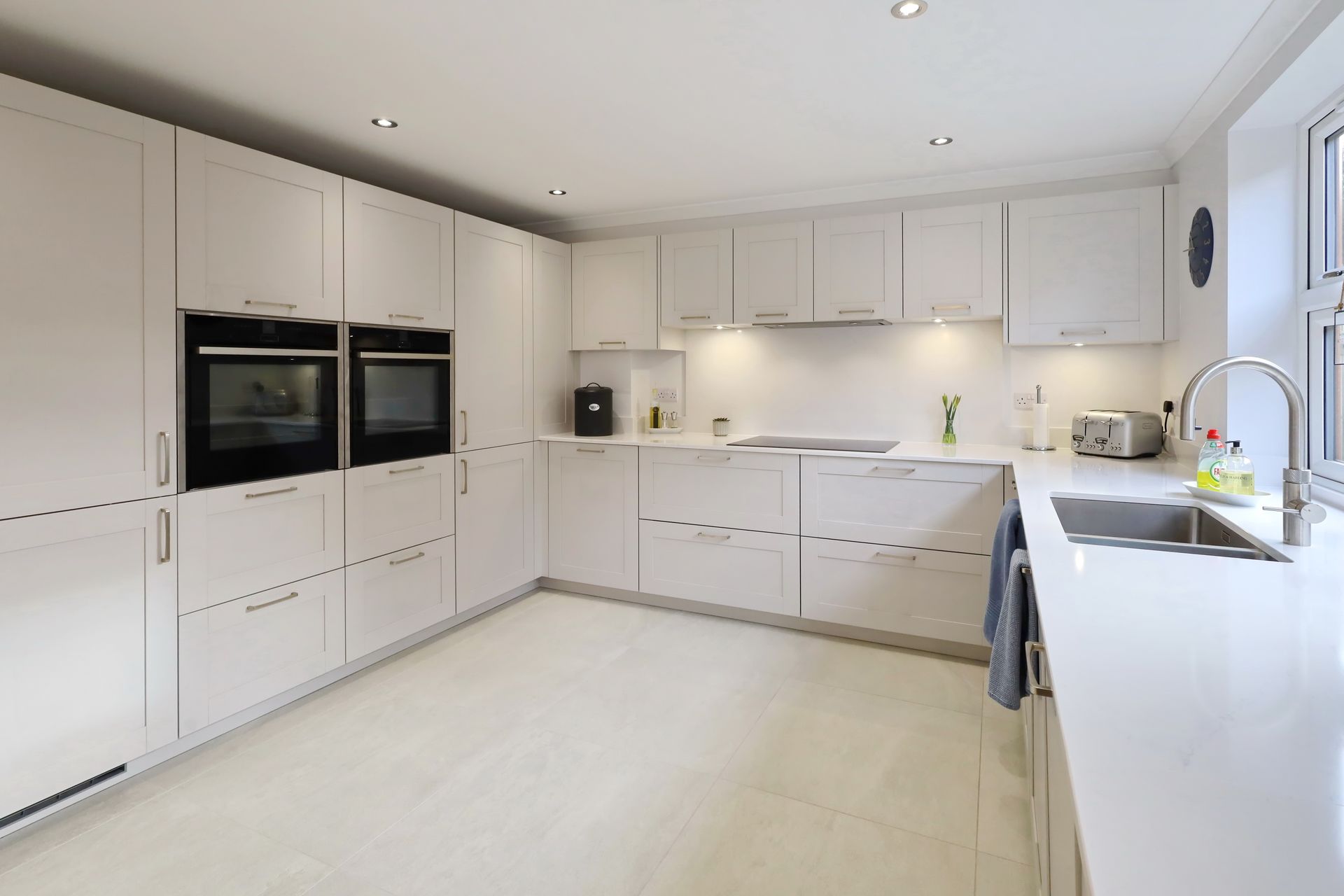 Harvey contemporary kitchen with grey, handleless units and teal furnishings. Designed by exact Kitchens in Wokingham.