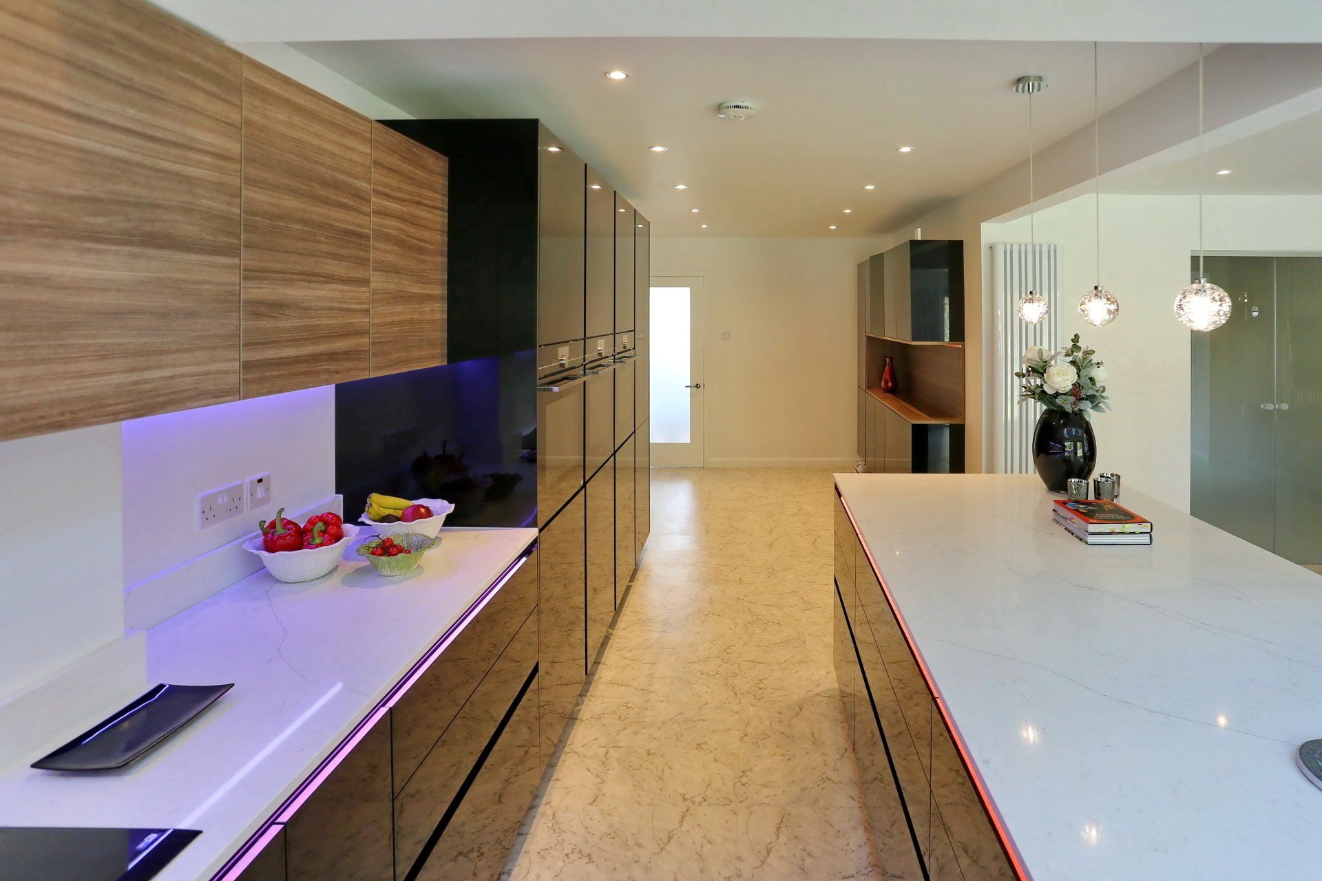 Modern kitchen with wooden and black cabinetry, white countertops, and a long island.