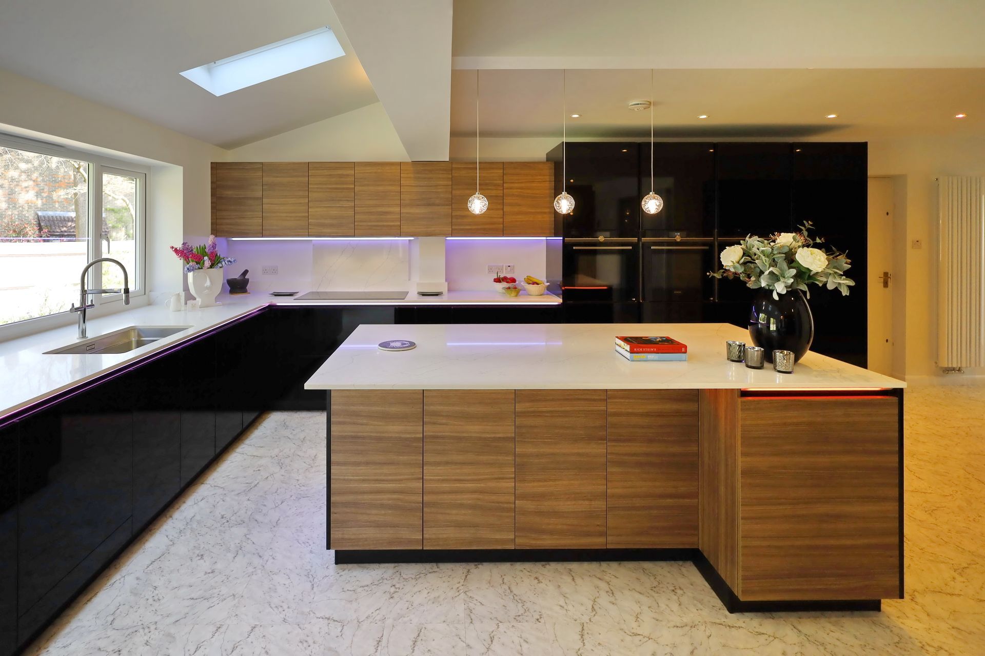 Modern kitchen with wooden and black cabinets, white countertops, and an island.