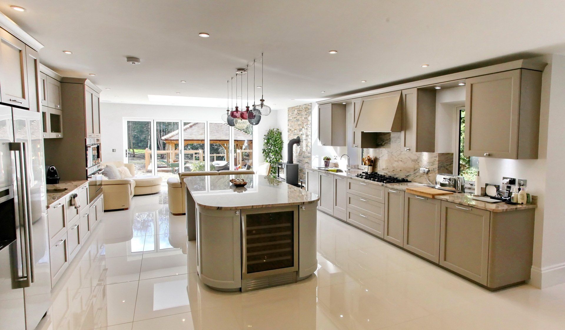 Spacious beige kitchen with island, cabinets, and a view of a patio.