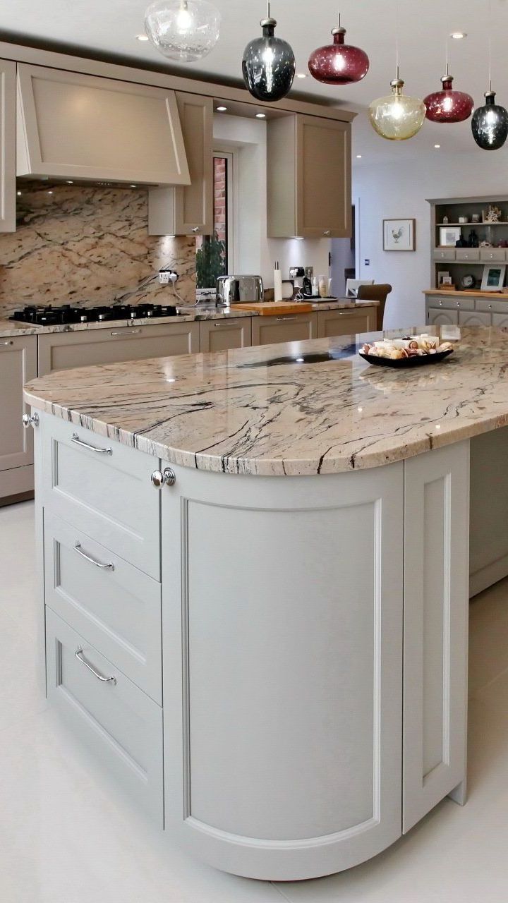 Kitchen with a light granite countertop island and white cabinetry.