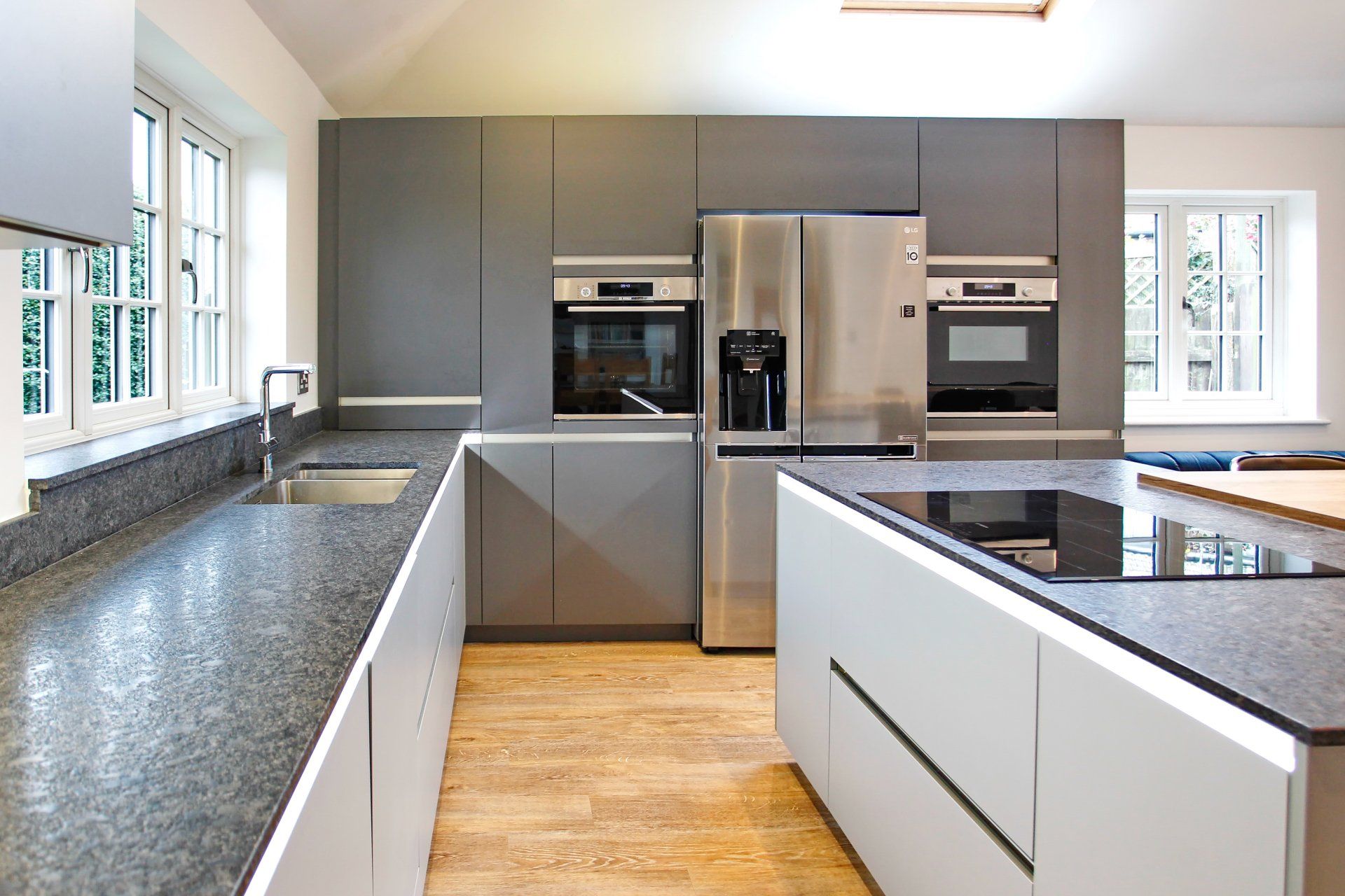 Harvey contemporary kitchen with grey, handleless units and teal furnishings. Designed by exact Kitchens in Wokingham.