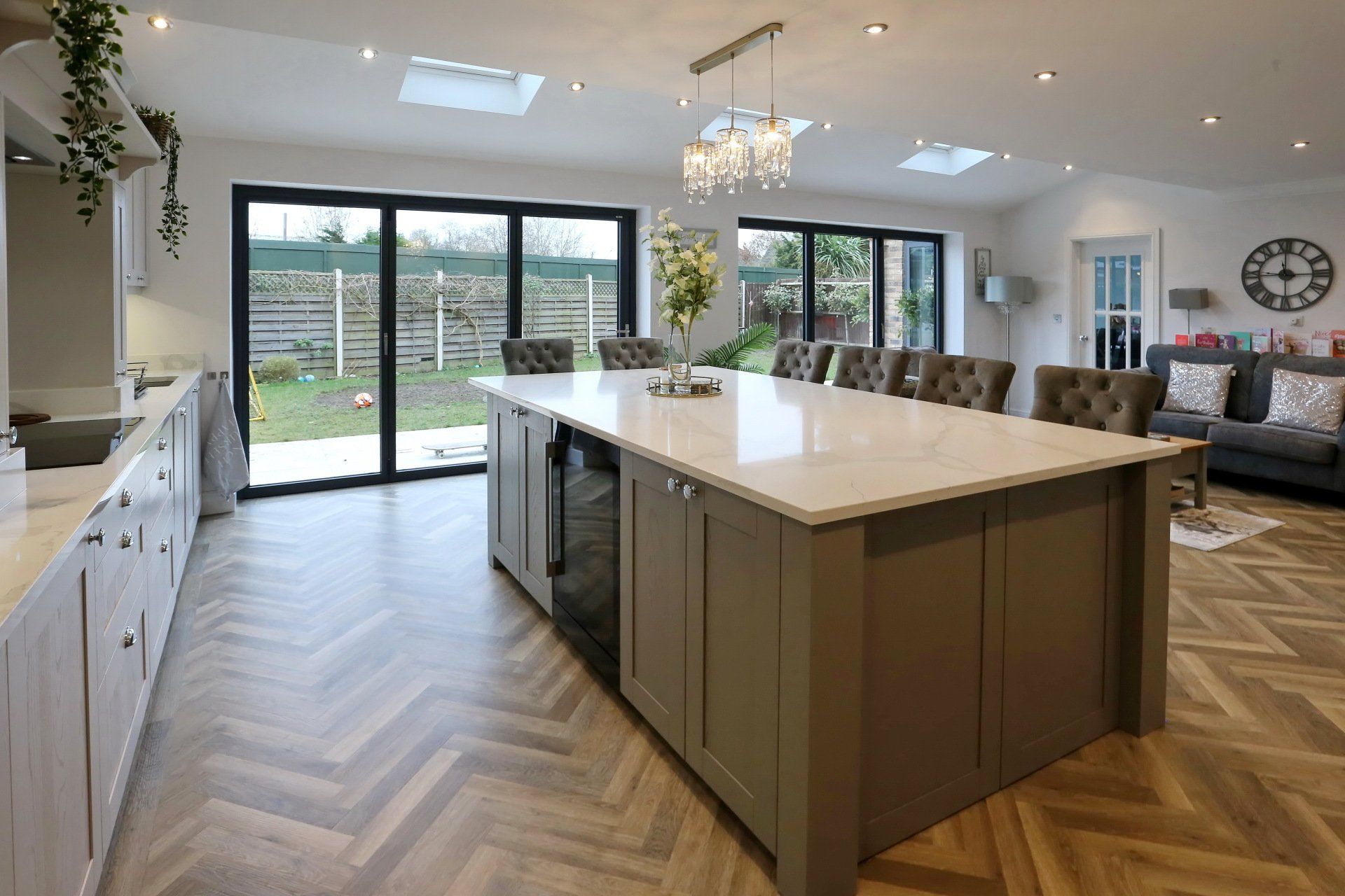 Spacious kitchen with large island, light cabinets, and sliding doors leading to a yard.
