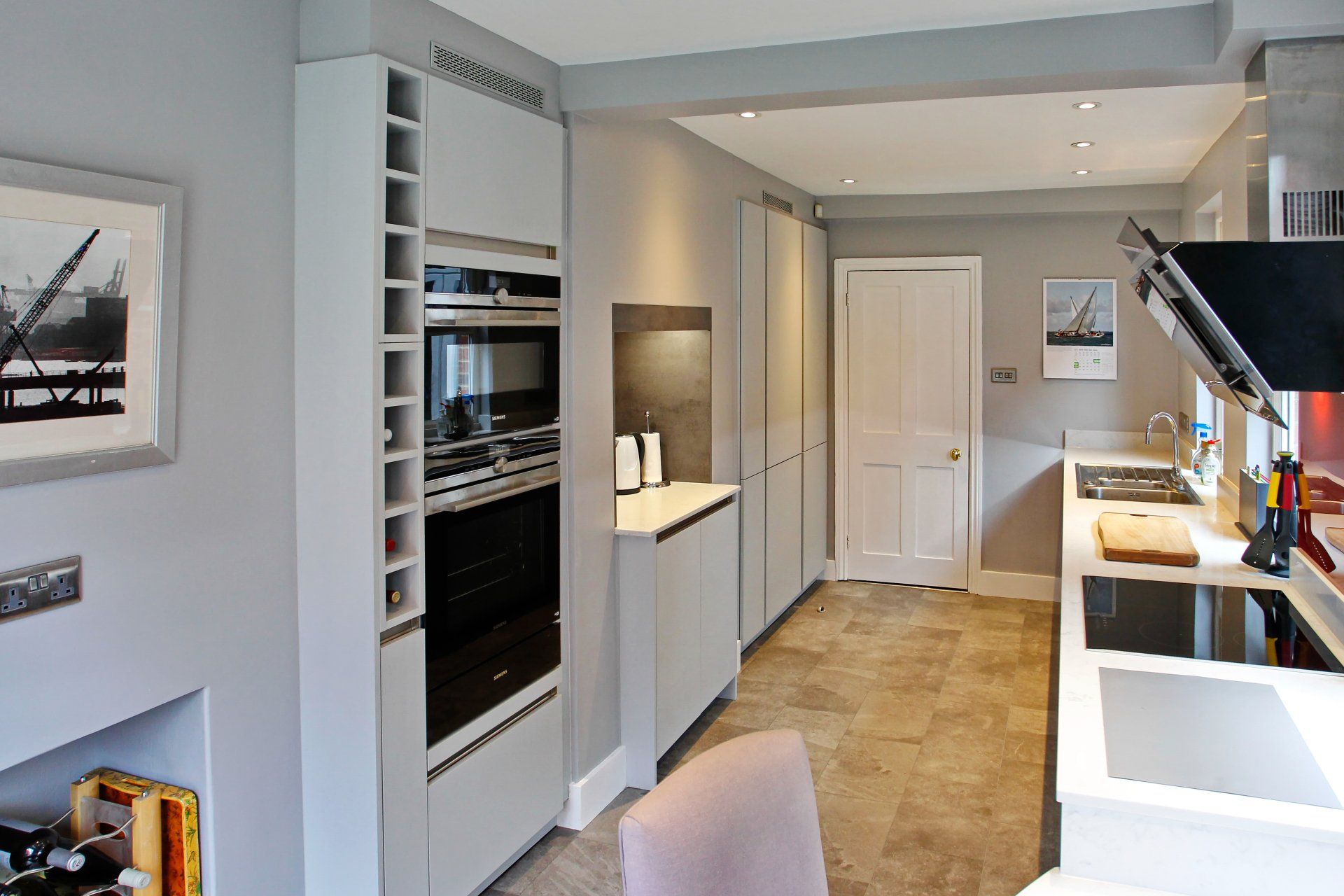 Modern kitchen with grey cabinets, appliances, and a light-colored floor.