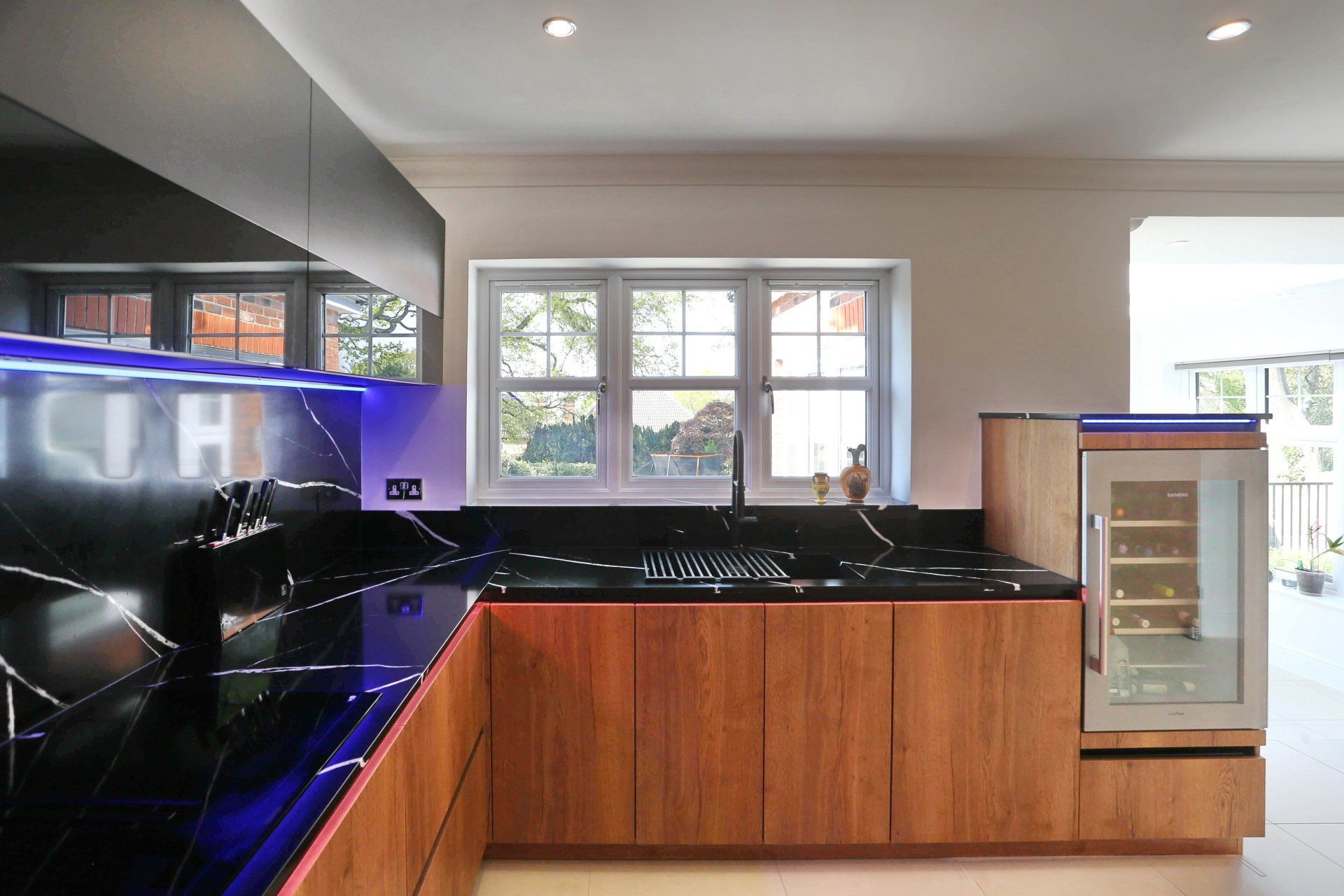 Harvey contemporary kitchen with grey, handleless units and teal furnishings. Designed by exact Kitchens in Wokingham.