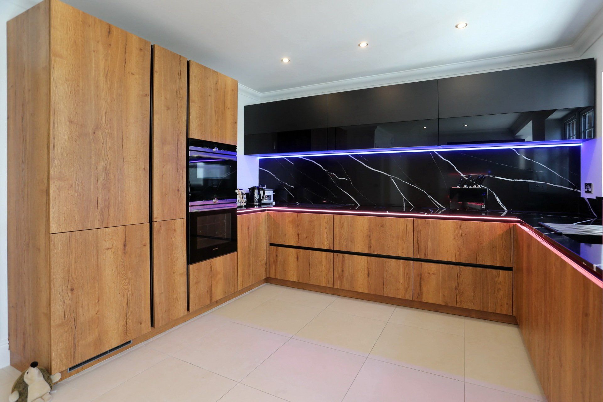 Harvey contemporary kitchen with grey, handleless units and teal furnishings. Designed by exact Kitchens in Wokingham.