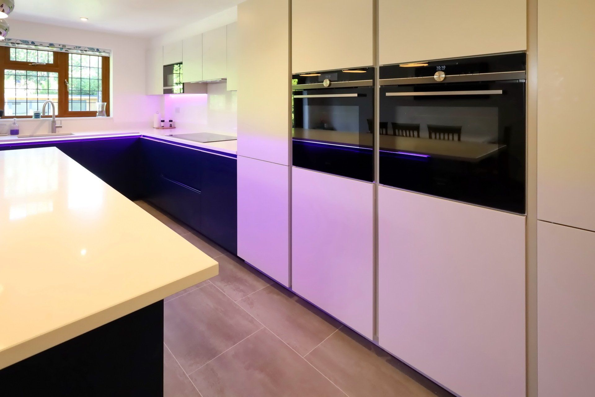 Harvey contemporary kitchen with grey, handleless units and teal furnishings. Designed by exact Kitchens in Wokingham.