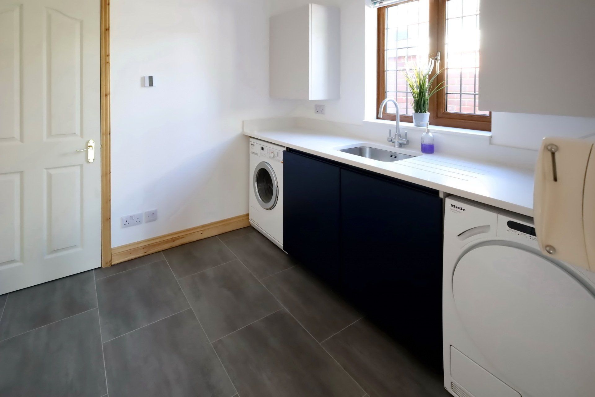 Harvey contemporary kitchen with grey, handleless units and teal furnishings. Designed by exact Kitchens in Wokingham.