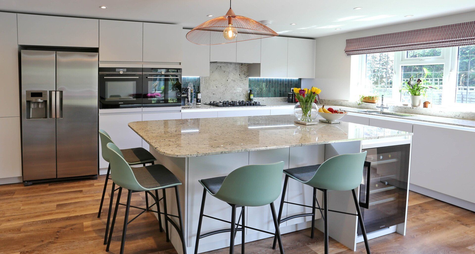 Harvey contemporary kitchen with grey, handleless units and teal furnishings. Designed by exact Kitchens in Wokingham.