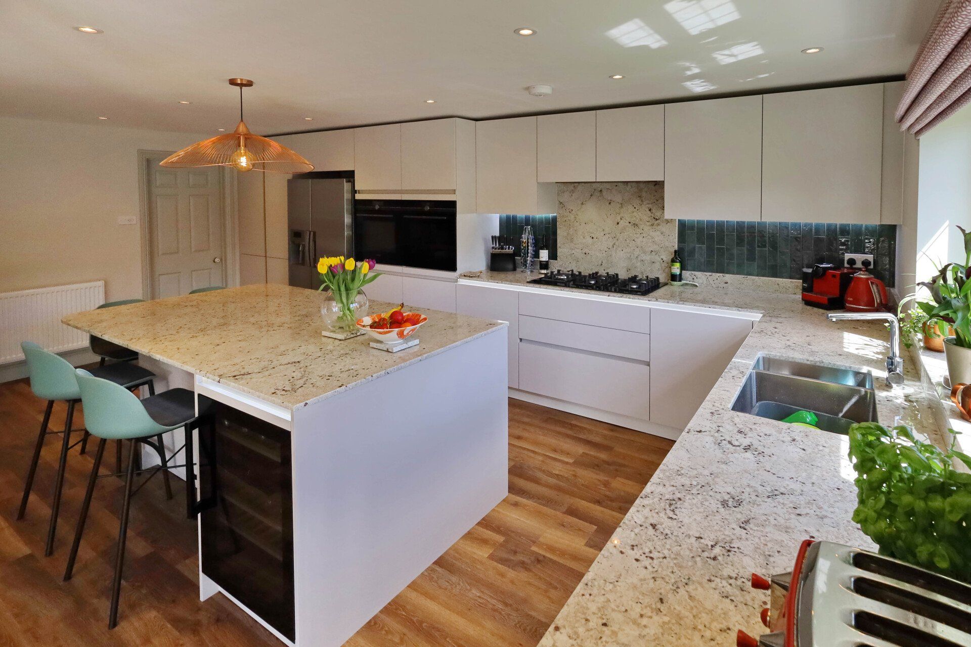 Harvey contemporary kitchen with grey, handleless units and teal furnishings. Designed by exact Kitchens in Wokingham.