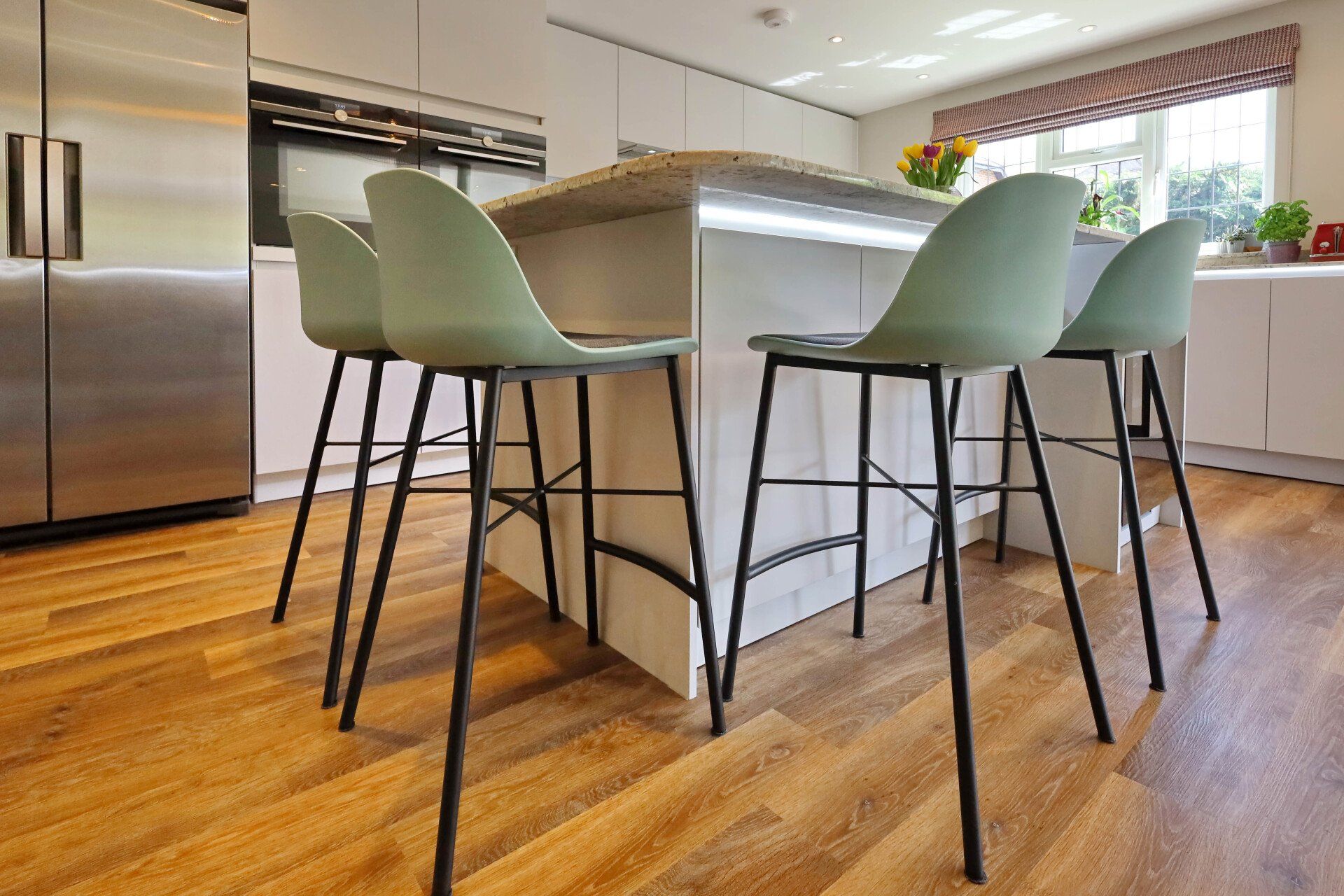 Harvey contemporary kitchen with grey, handleless units and teal furnishings. Designed by exact Kitchens in Wokingham.