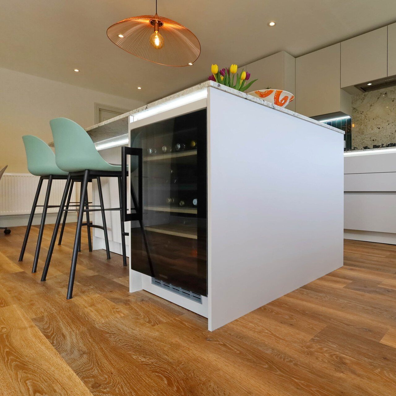 Harvey contemporary kitchen with grey, handleless units and teal furnishings. Designed by exact Kitchens in Wokingham.
