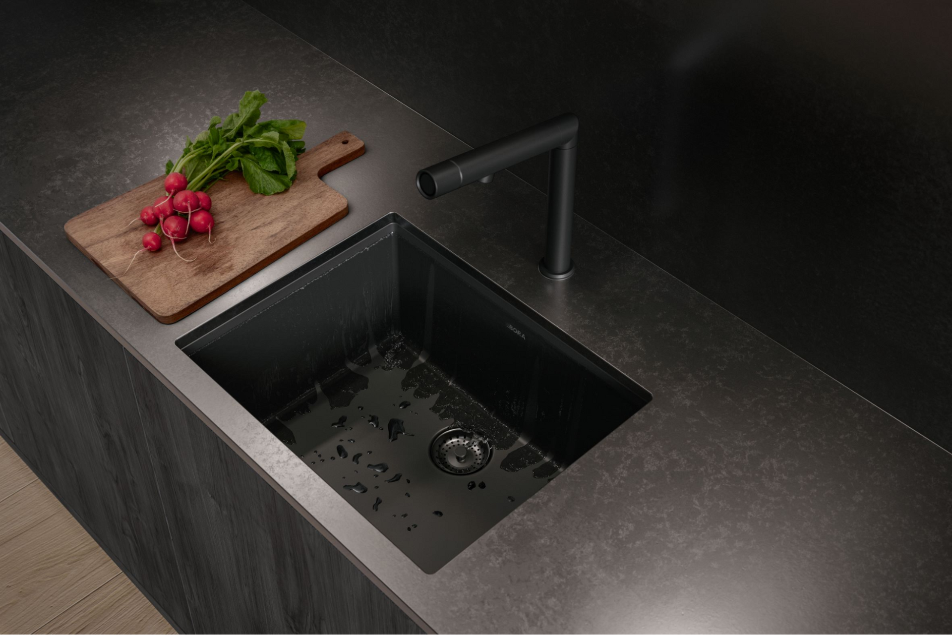 Black kitchen sink with a faucet, cutting board with radishes, dark countertop.