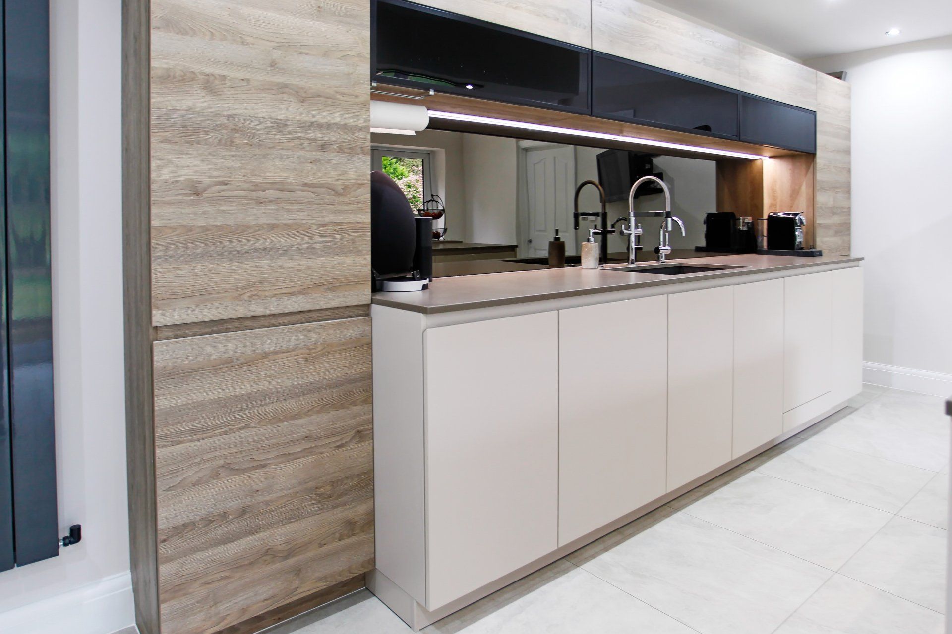 Harvey contemporary kitchen with grey, handleless units and teal furnishings. Designed by exact Kitchens in Wokingham.