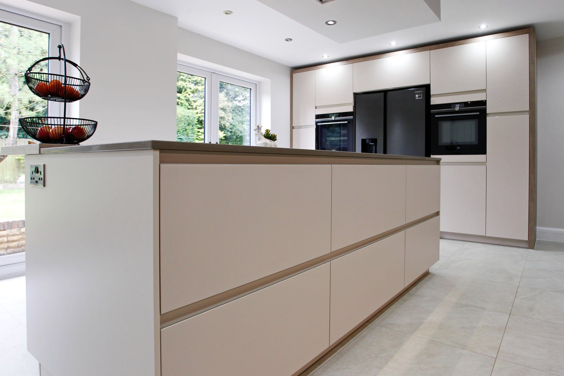 Harvey contemporary kitchen with grey, handleless units and teal furnishings. Designed by exact Kitchens in Wokingham.