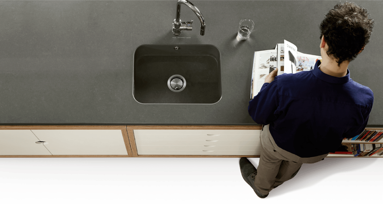 Man browsing worktop brochure leaning on a graphite grey Silestone worktop
