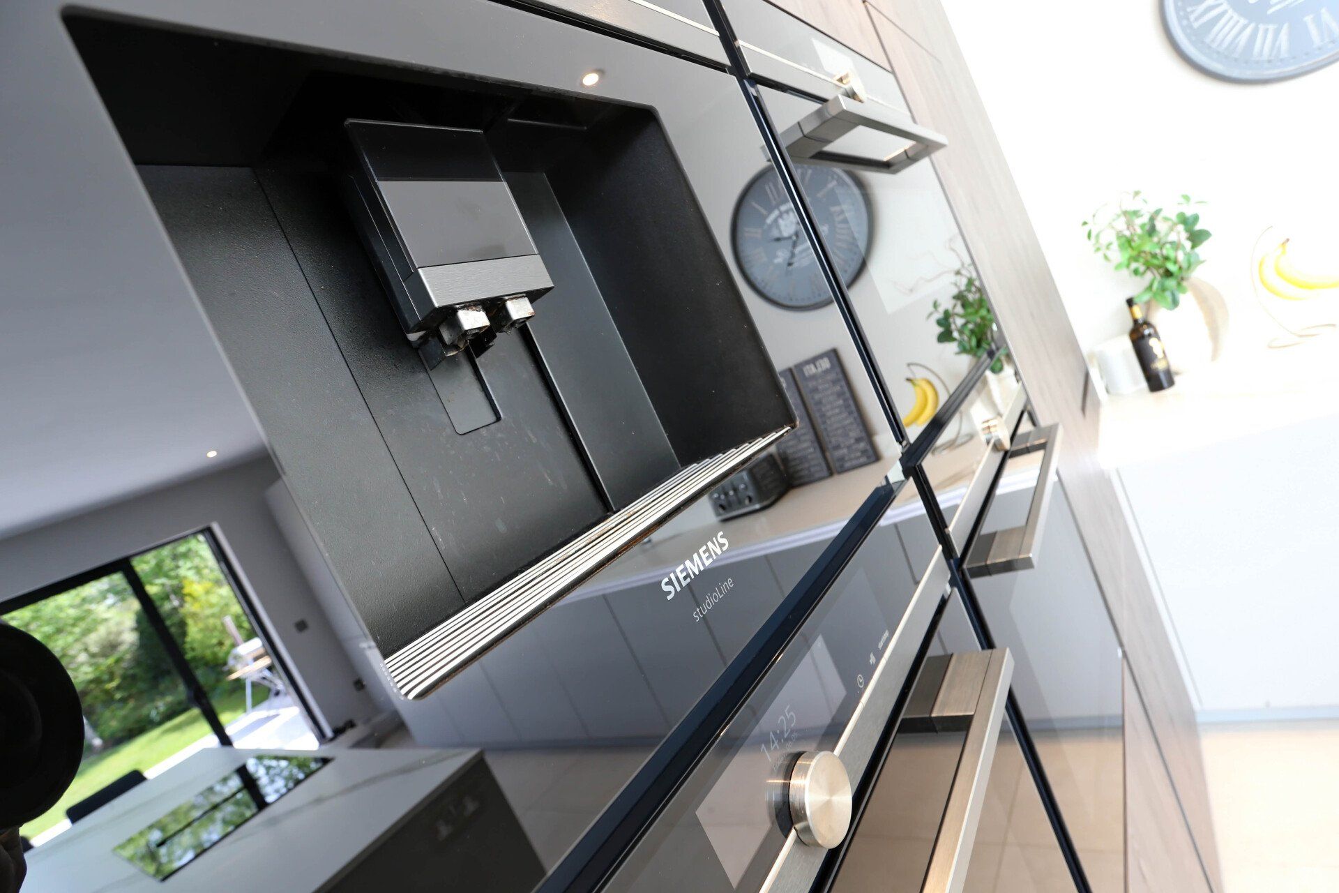 Modern black kitchen appliances, including oven, in a bright space.