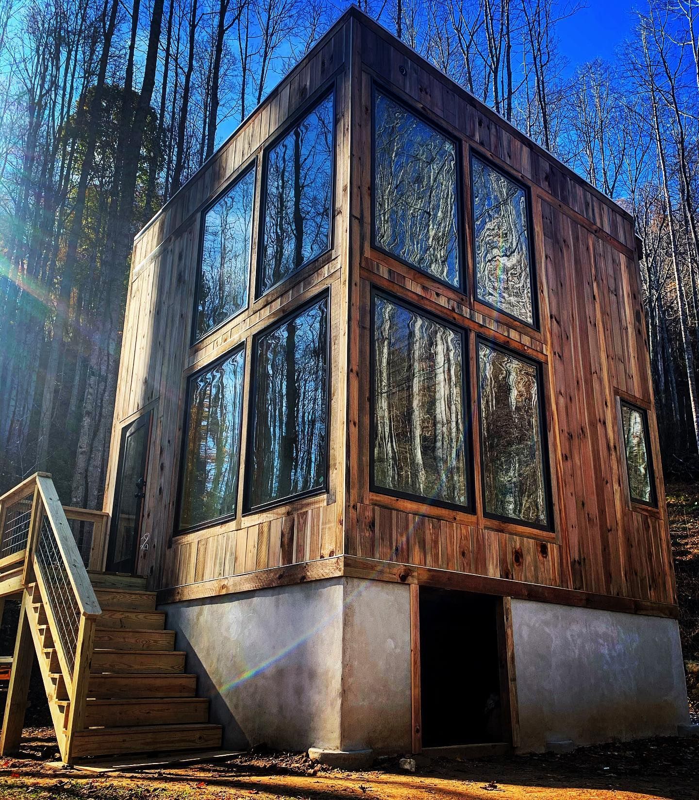 A wooden house with a lot of windows and stairs
