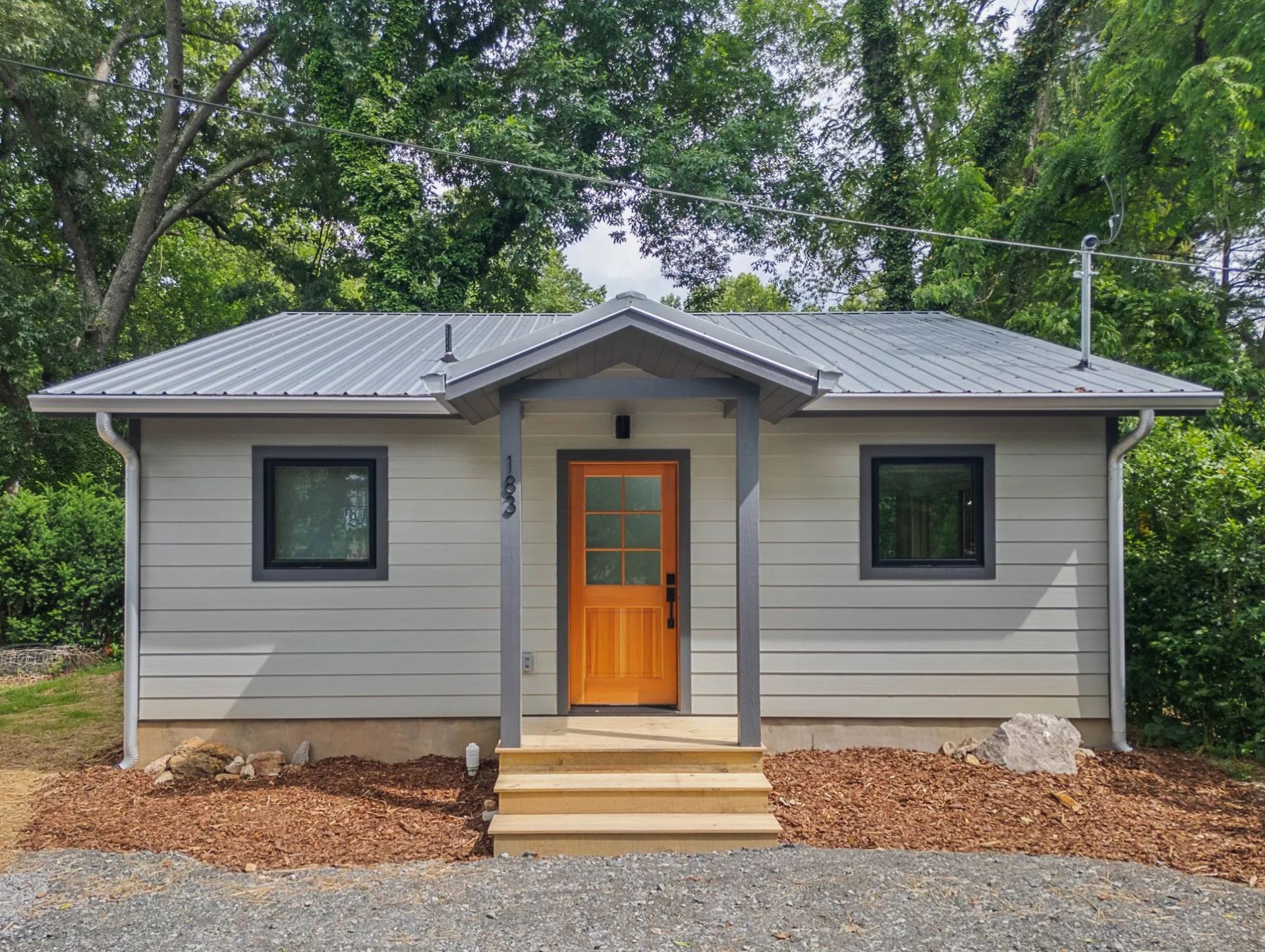 Modern tiny home with large windows and wood siding installed by Nanostead in Weaverville, NC.