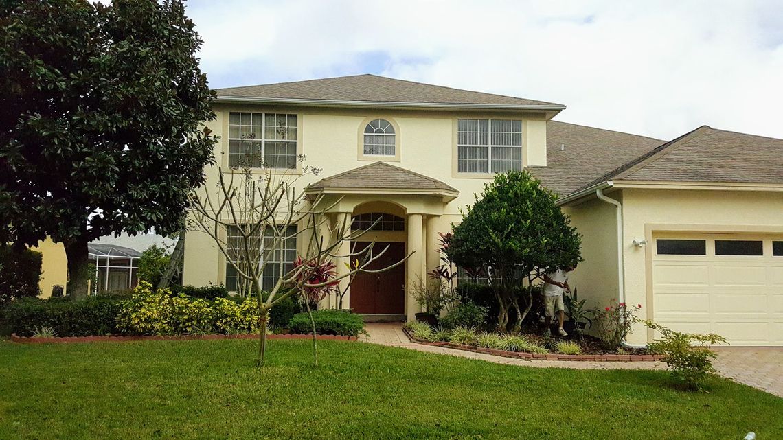 A white house with a brown door and a garage