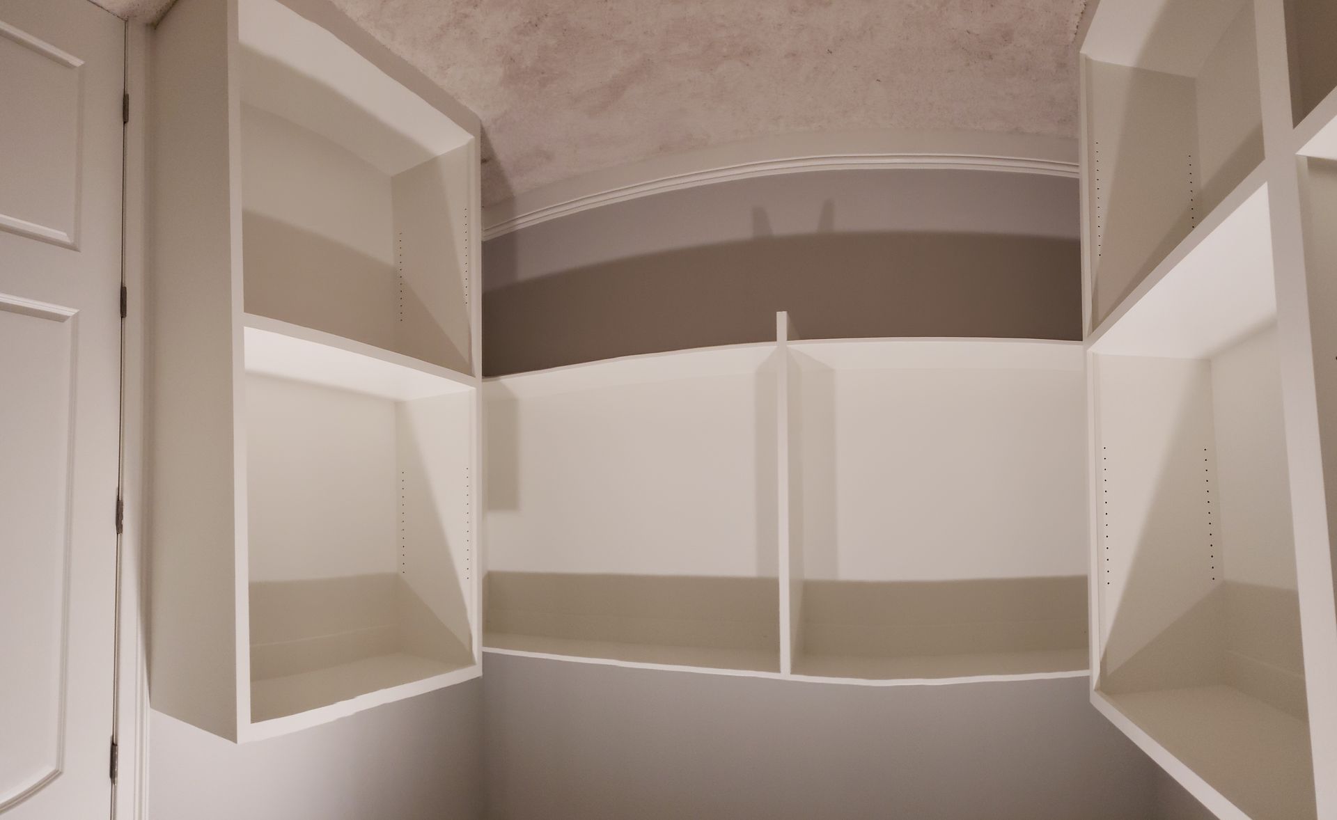 An empty closet with shelves and a door