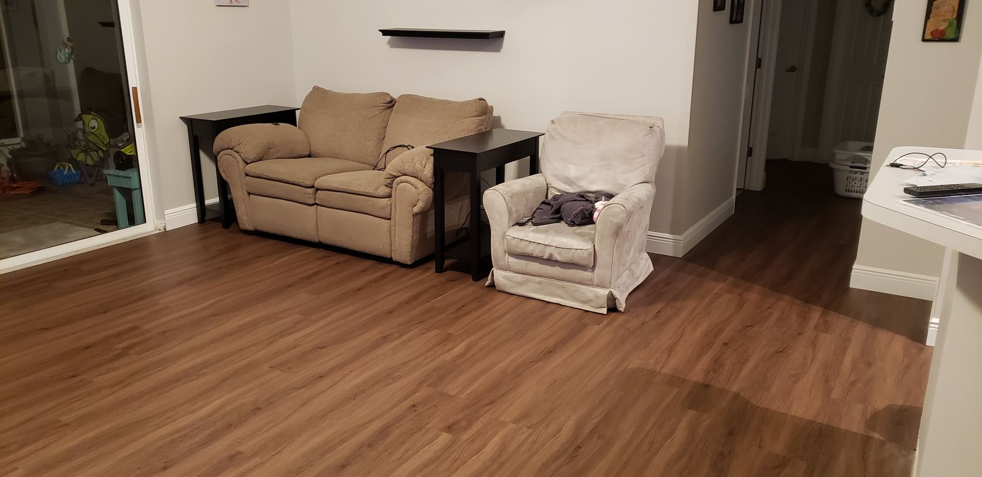 A living room with hardwood floors , a couch and a chair.