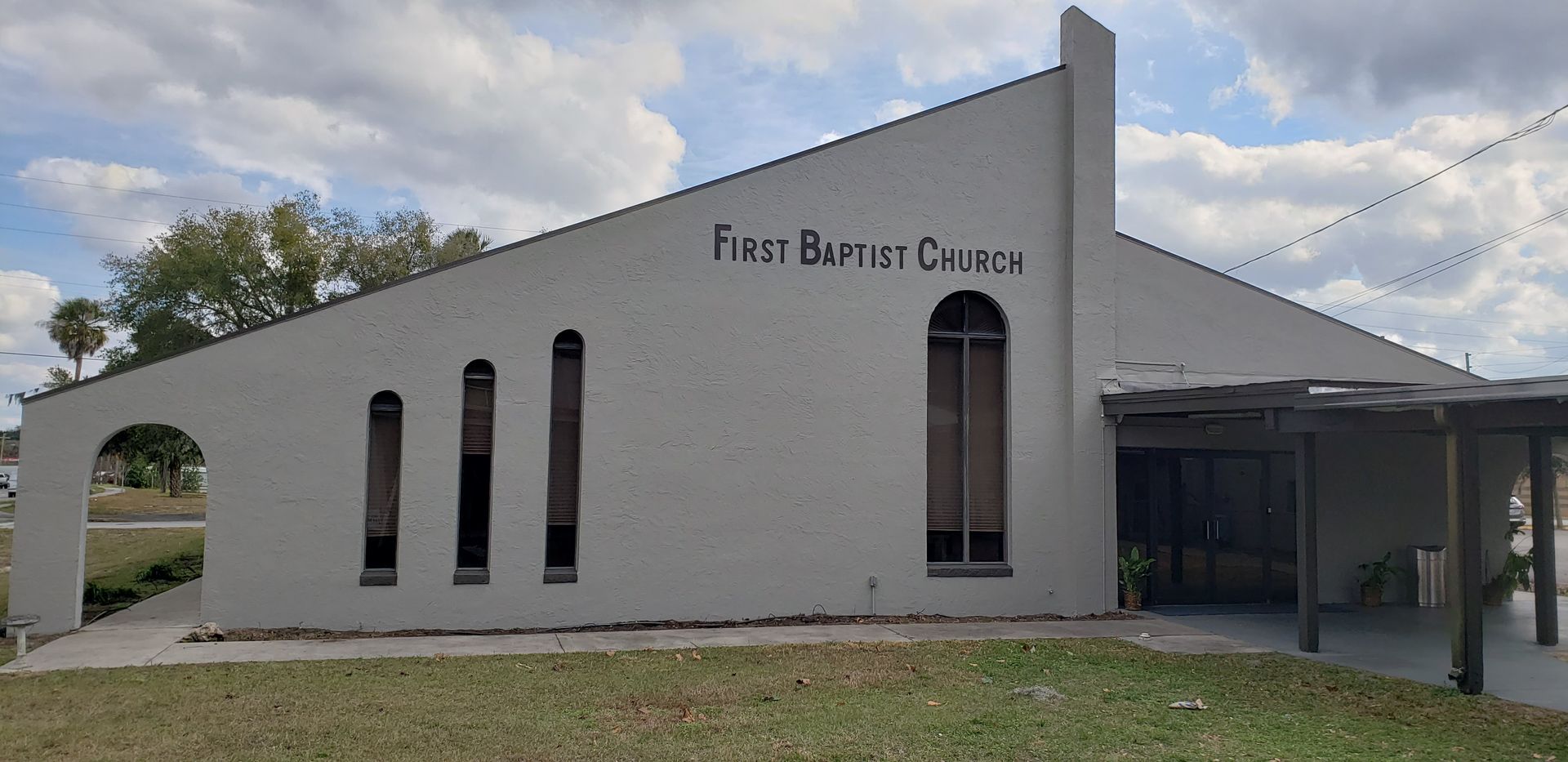 A white building with the words first baptist church written on it