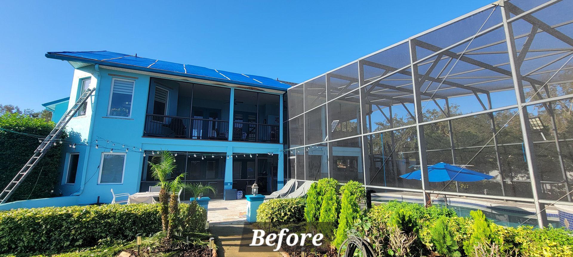 A blue house with a screened in area in front of it.