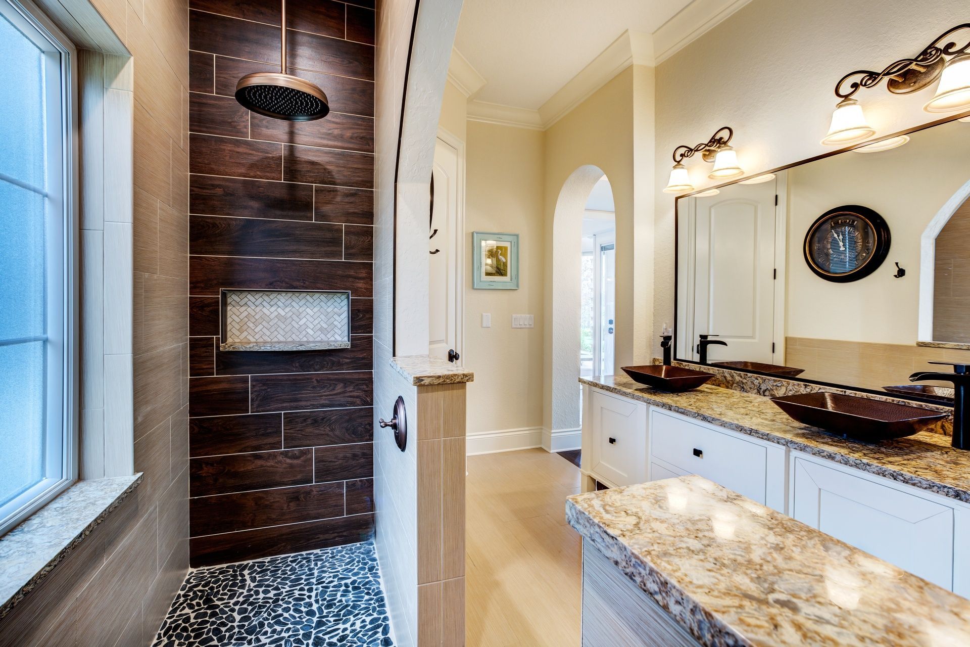 A bathroom with a walk in shower and two sinks