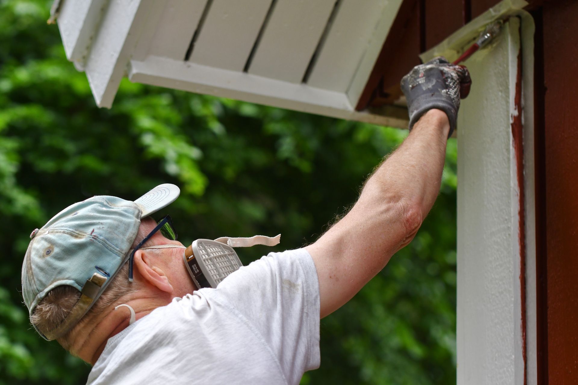 A man is painting a house with a brush.
