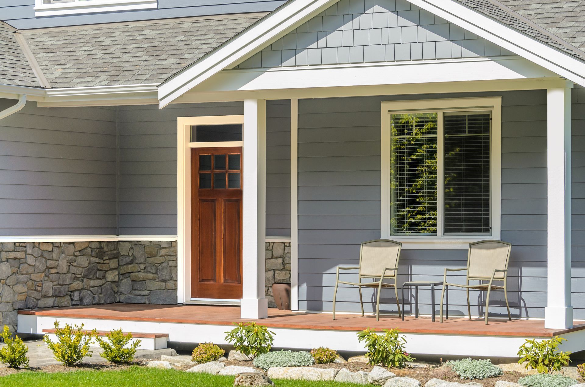 A house with a porch and a table and chairs on it.