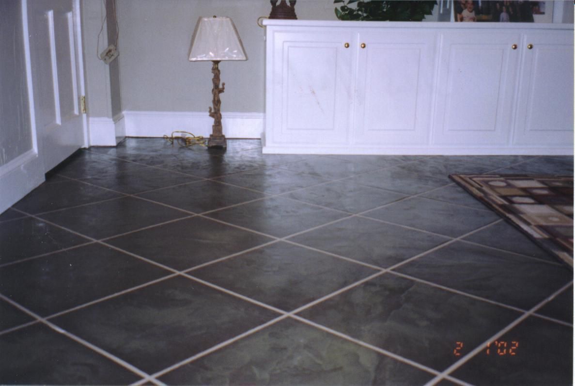 Living room with dark tiled floor, white cabinets, a floor lamp, and a patterned rug edge