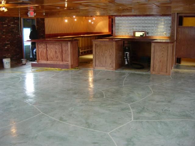 Empty wood-paneled lobby with a polished stone floor and built-in reception counters