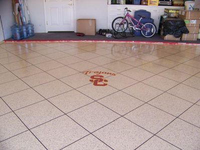 Tiled garage floor with a red emblem, bicycles, and storage items along the back wall