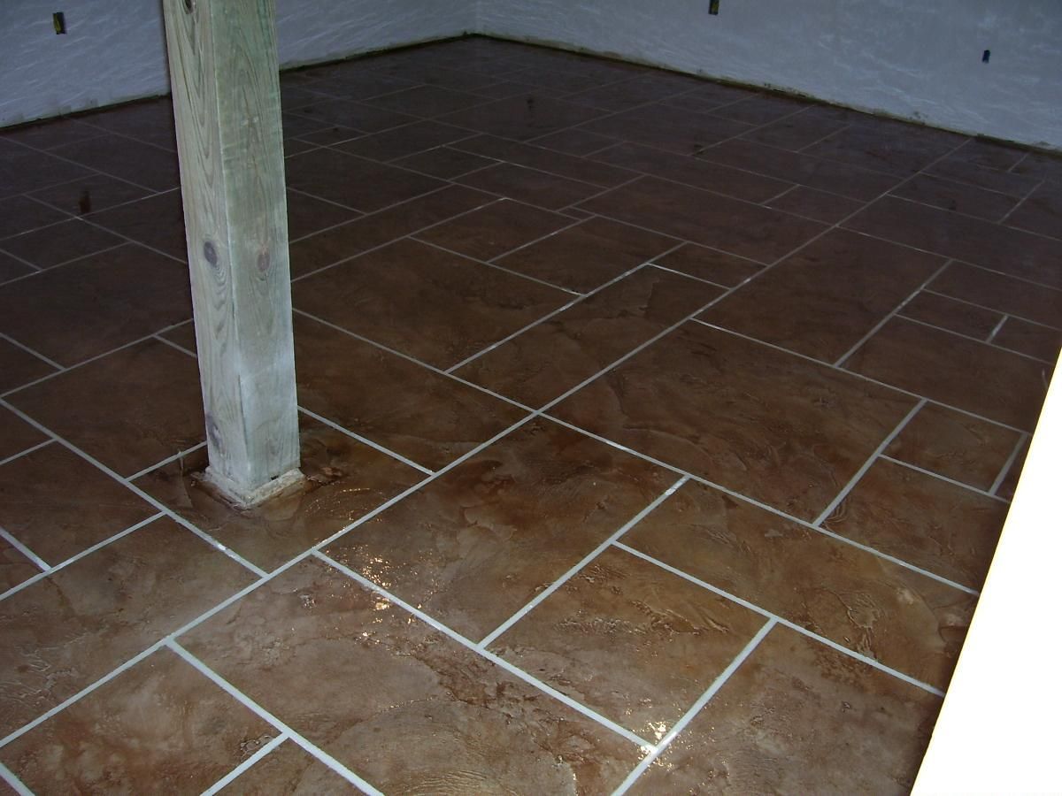Tiled floor under a wooden post, with a white wall and corner in the background