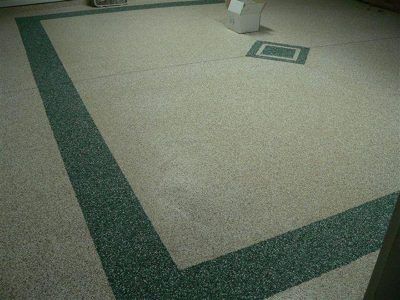Indoor carpeted floor with dark green border and a small square floor vent near the top.