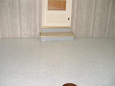 A small door centered on a wood-paneled wall above a gray textured floor.