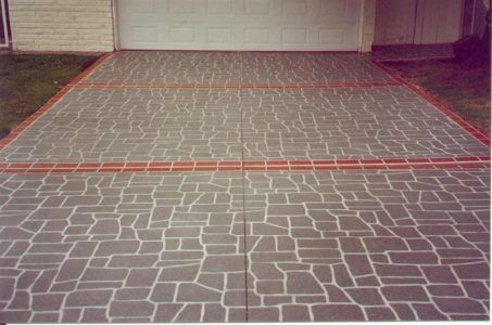 Textured driveway with red painted lines in front of a garage door