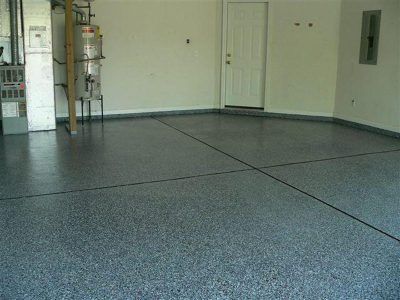 Empty garage interior with gray speckled floor and white walls