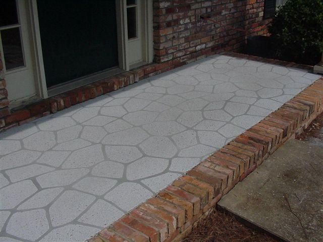 Brick house entry with a light stone walkway and raised brick border