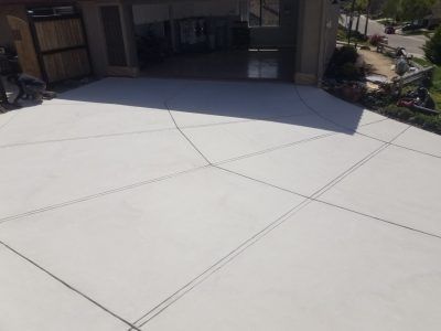 Fresh white concrete driveway leading to a shaded garage entrance