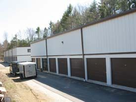 A truck is parked in front of a row of storage units.